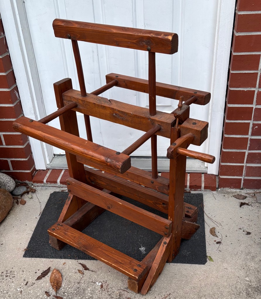 Wooden warping weasel sitting on a back porch.